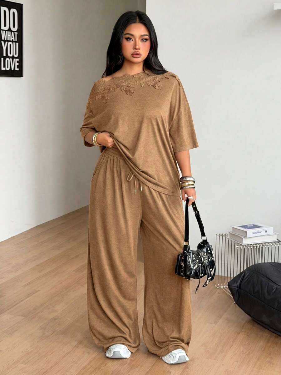 Women's casual two-piece outfit featuring a loose short-sleeve asymmetrical neck t-shirt and matching long wide leg pants with pockets.