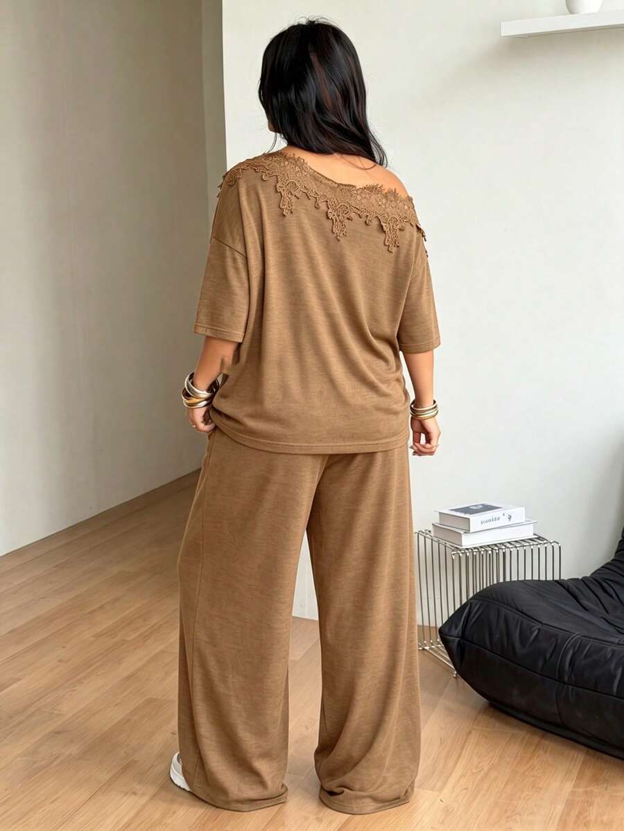 Women's casual two-piece outfit featuring a loose short-sleeve asymmetrical neck t-shirt and matching long wide leg pants with pockets.
