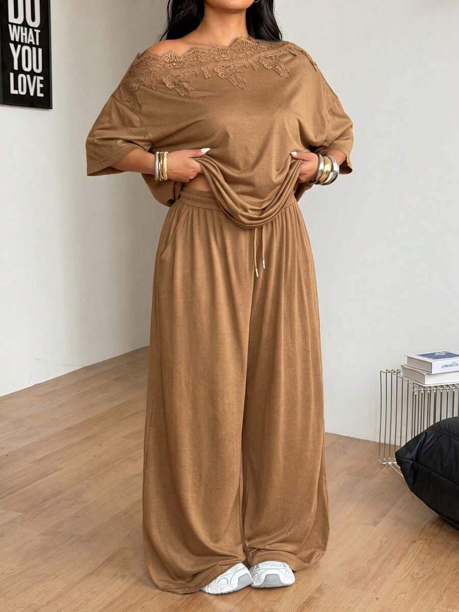 Women's casual two-piece outfit featuring a loose short-sleeve asymmetrical neck t-shirt and matching long wide leg pants with pockets.