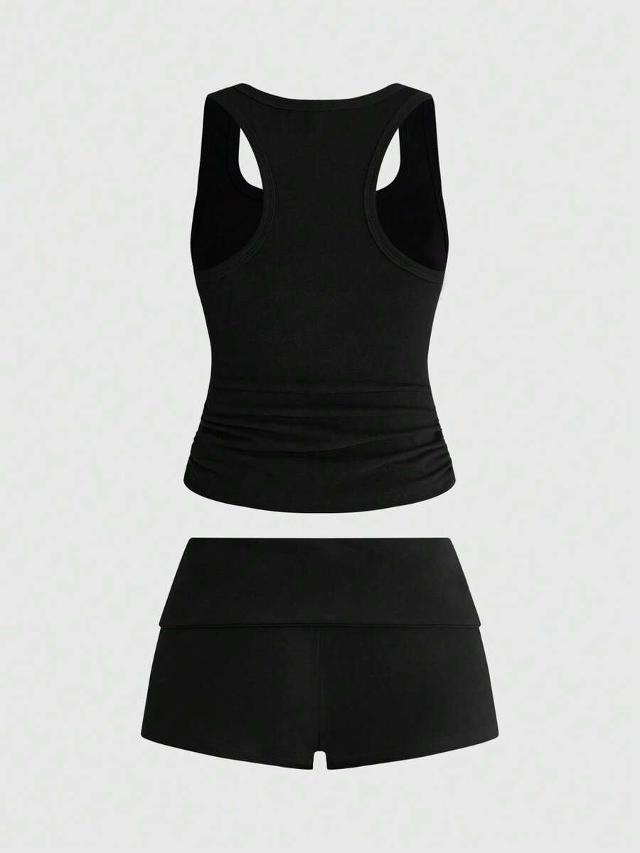 Punk-inspired two-piece set with a fitted scoop neck slogan tank top featuring cross and rhinestone details paired with ultra low waist mini shorts.