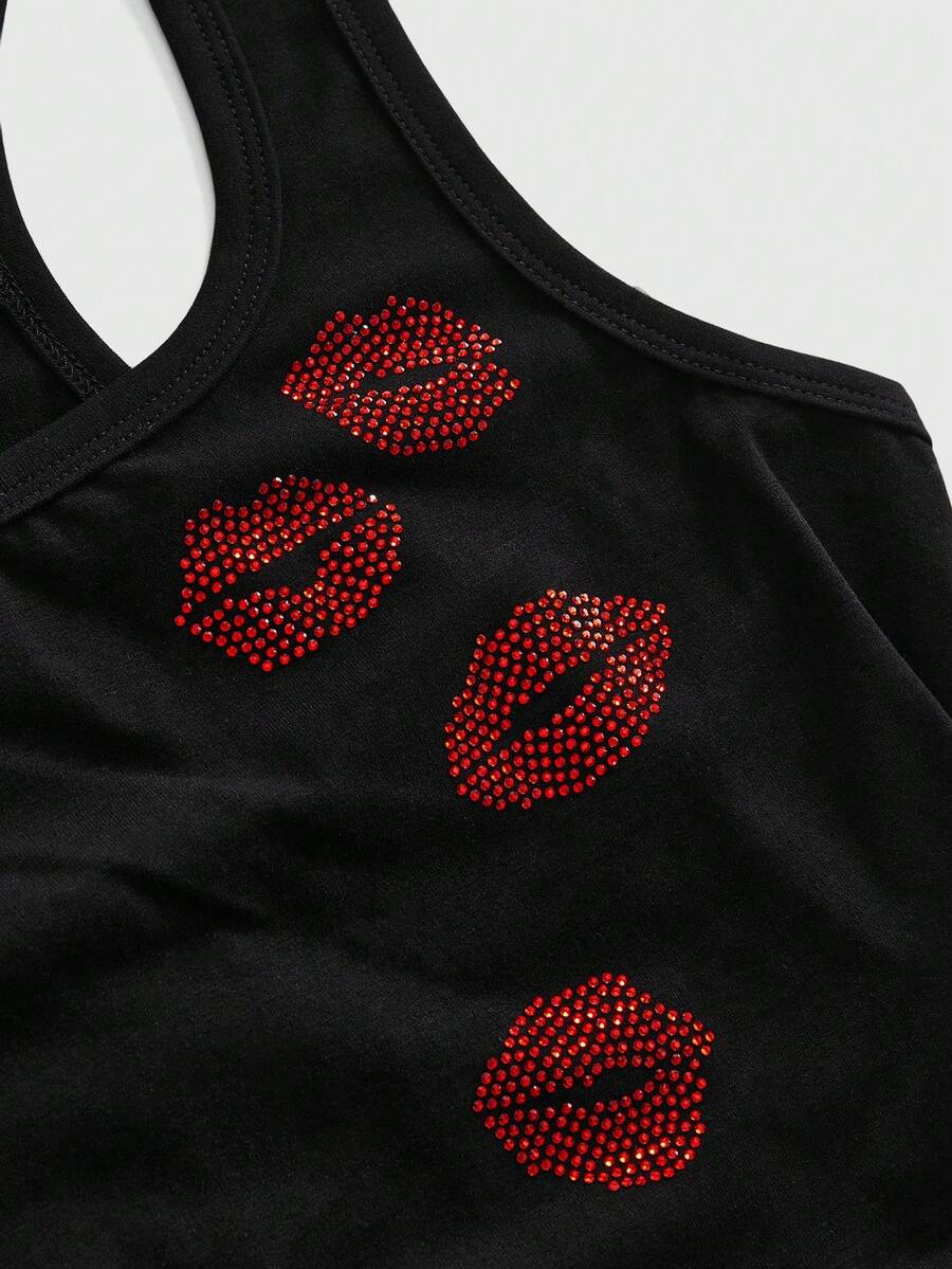 Punk-inspired two-piece set with a fitted scoop neck slogan tank top featuring cross and rhinestone details paired with ultra low waist mini shorts.
