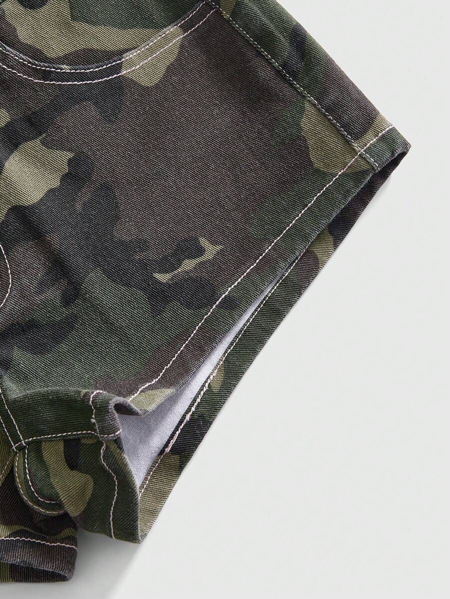 Women's ultra low waist mini shorts with back pockets, zipper fly, button detail, random print, and star patch in a grunge punk Y2K style.