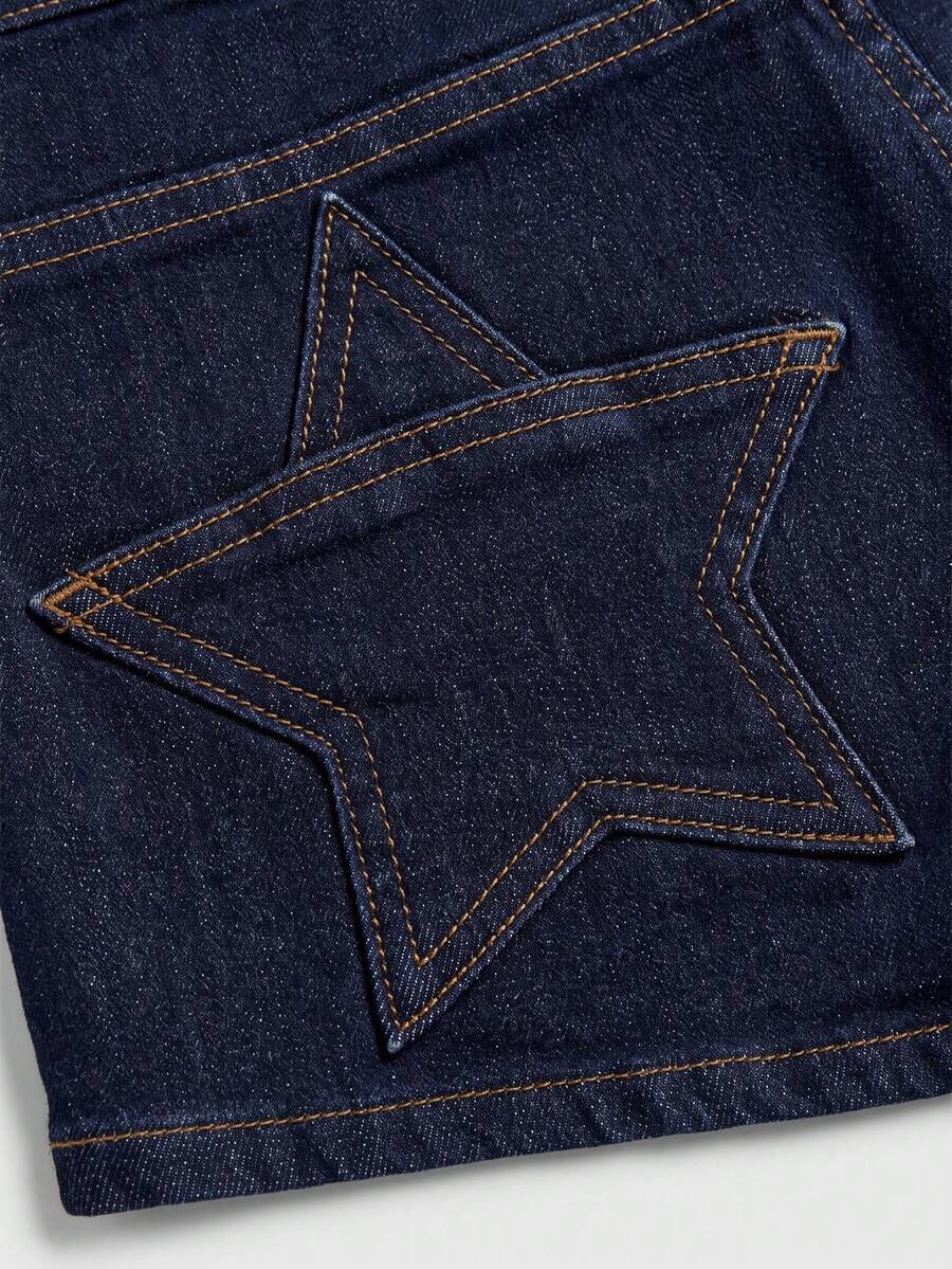 Women's ultra low waist mini shorts with back pockets, zipper fly, button detail, random print, and star patch in a grunge punk Y2K style.
