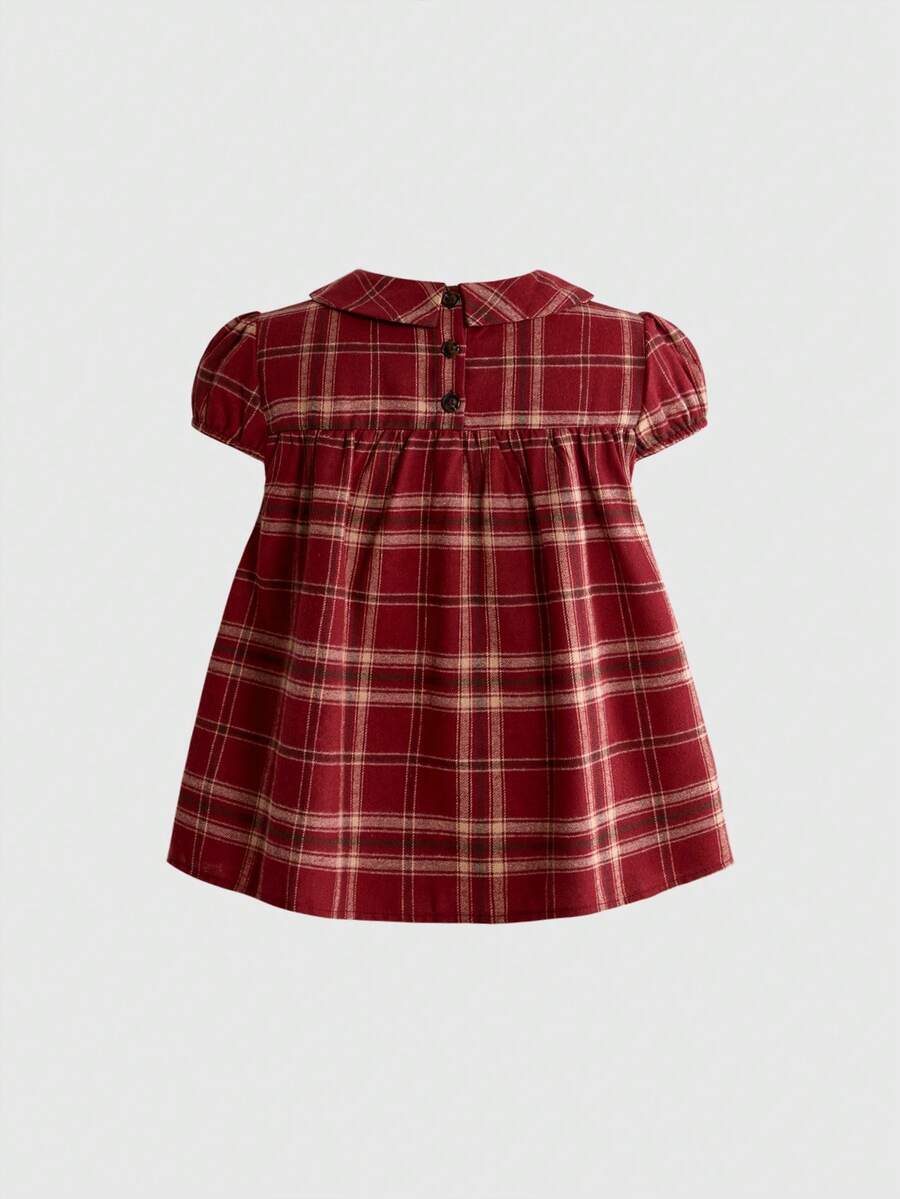 Short sleeve plaid shirt for women featuring a Peter Pan collar with a bow accent, puff sleeves, and a flared hem.