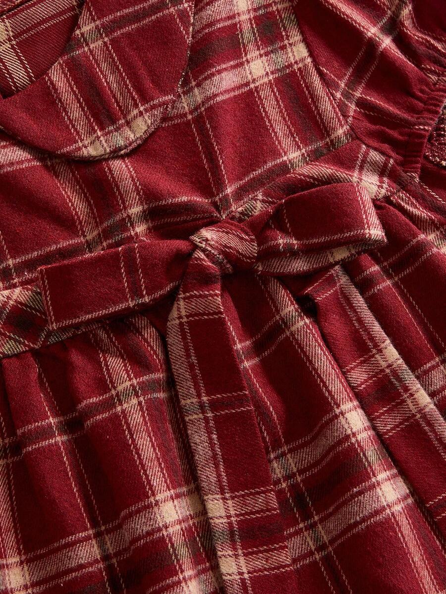 Short sleeve plaid shirt for women featuring a Peter Pan collar with a bow accent, puff sleeves, and a flared hem.