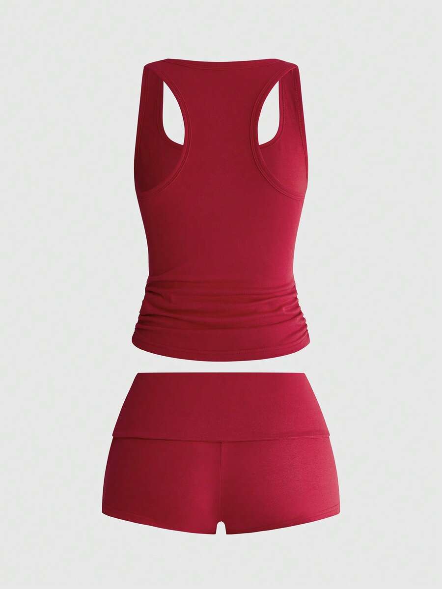 Punk-inspired two-piece set with a fitted scoop neck slogan tank top featuring cross and rhinestone details paired with ultra low waist mini shorts.