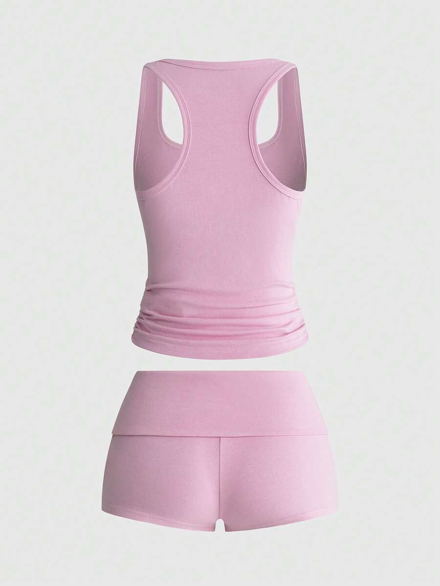 Punk-inspired two-piece set with a fitted scoop neck slogan tank top featuring cross and rhinestone details paired with ultra low waist mini shorts.