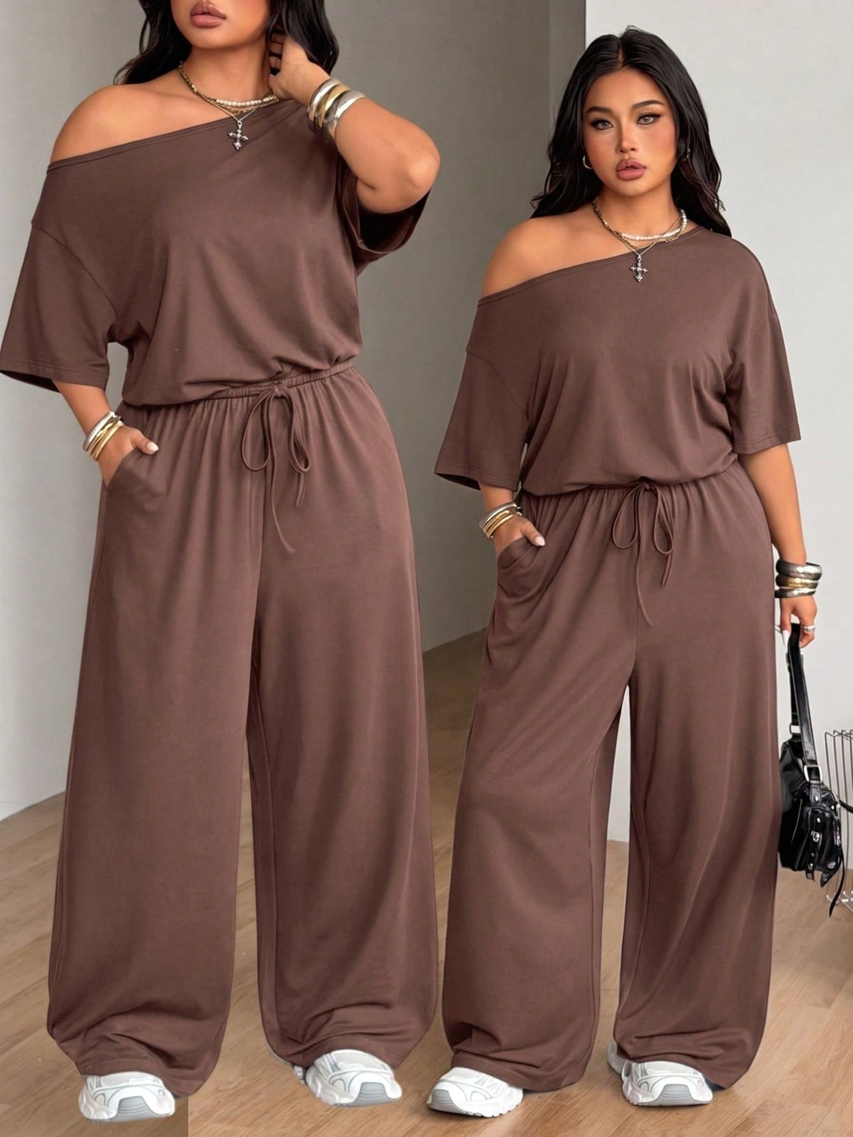 Plus size women's wide leg jumpsuit in dark grey featuring an asymmetrical neckline, short batwing sleeves, and a drawstring high waist with side pockets.