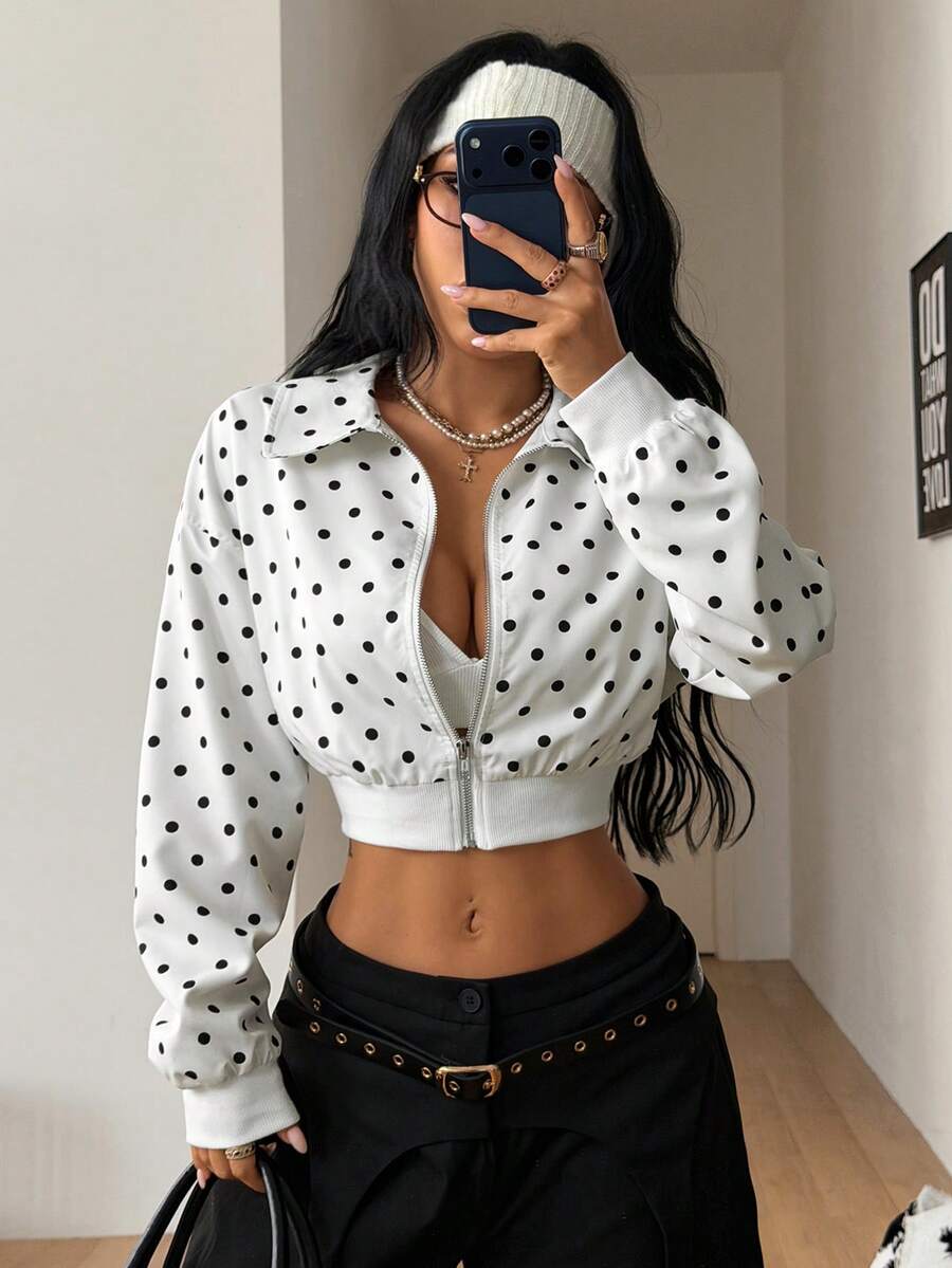 Women's cropped zip up jacket in black and white woven fabric featuring a collared neckline, long regular sleeves, front zipper, tight hem, and side pockets.