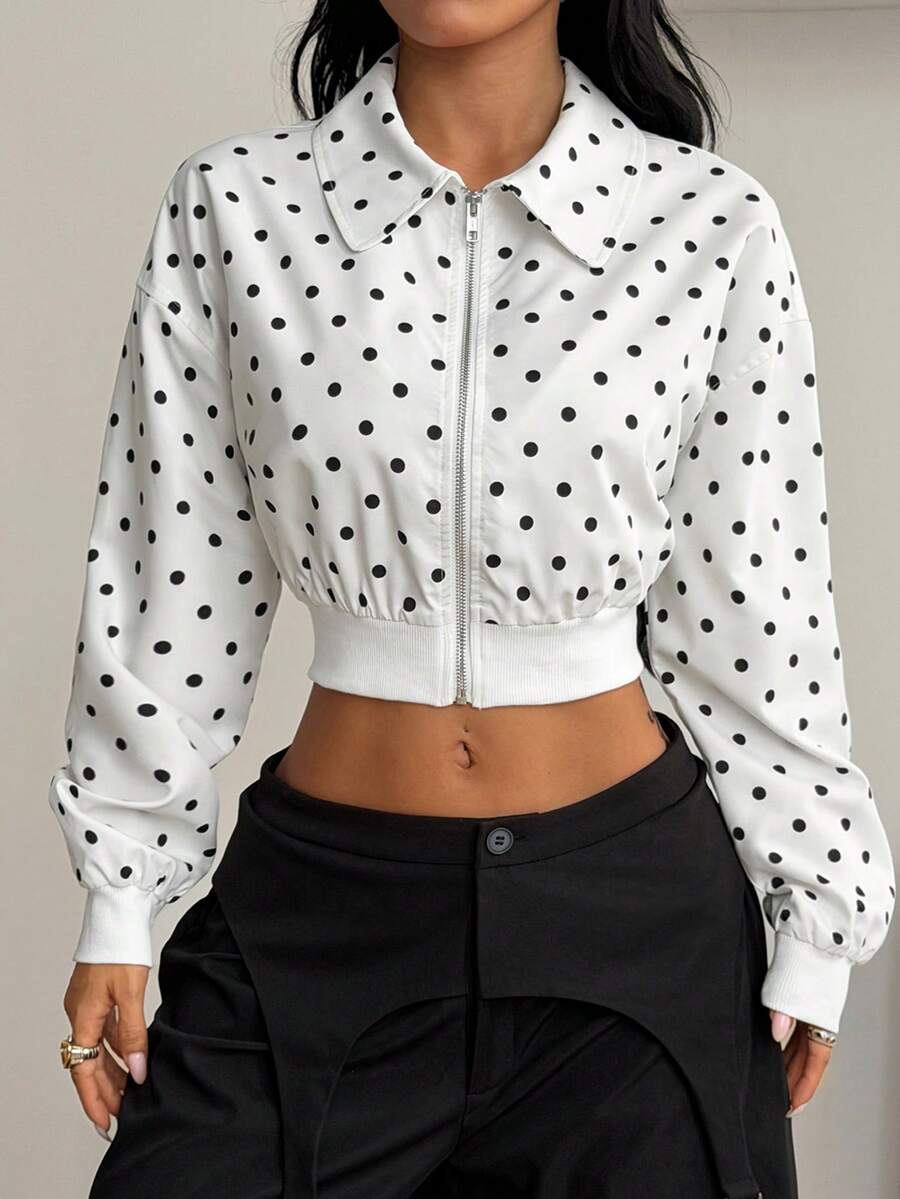 Women's cropped zip up jacket in black and white woven fabric featuring a collared neckline, long regular sleeves, front zipper, tight hem, and side pockets.