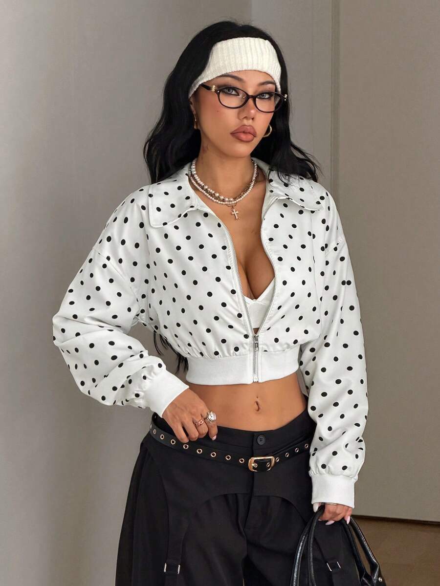 Women's cropped zip up jacket in black and white woven fabric featuring a collared neckline, long regular sleeves, front zipper, tight hem, and side pockets.