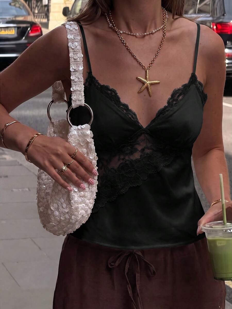 Women's woven spaghetti strap camisole top featuring contrast lace detailing and a regular fit.