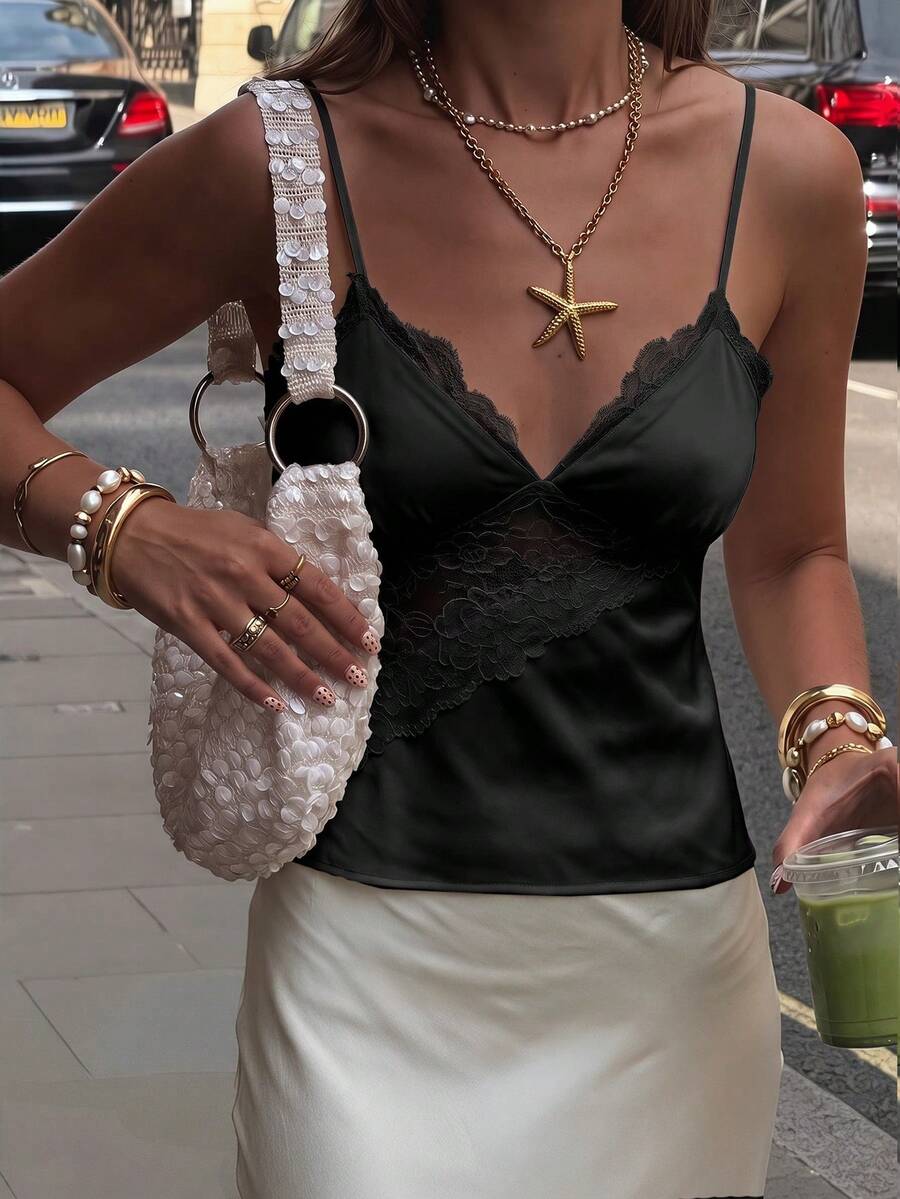 Women's woven spaghetti strap camisole top featuring contrast lace detailing and a regular fit.