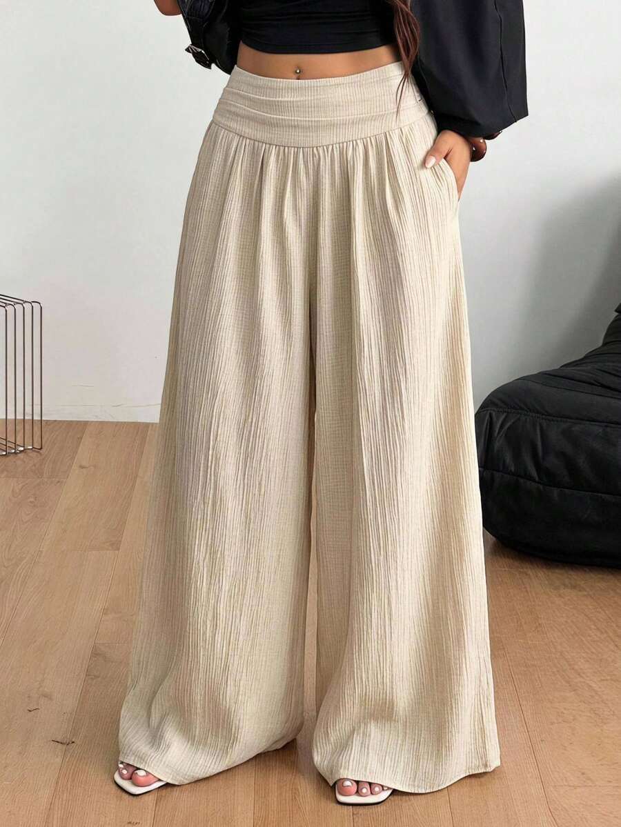 Women's plus size high-waist pleated wide leg pants in textured woven fabric with pockets
