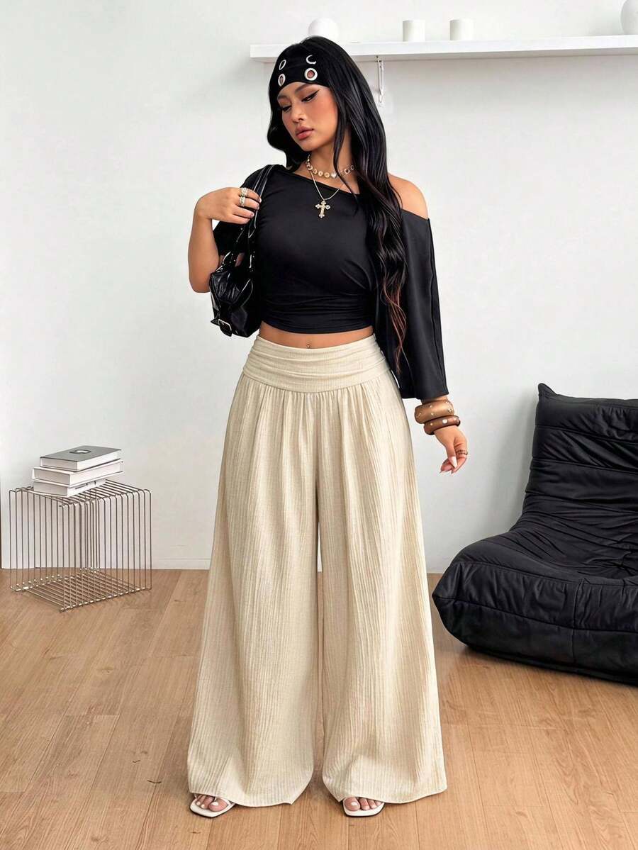 Women's plus size high-waist pleated wide leg pants in textured woven fabric with pockets