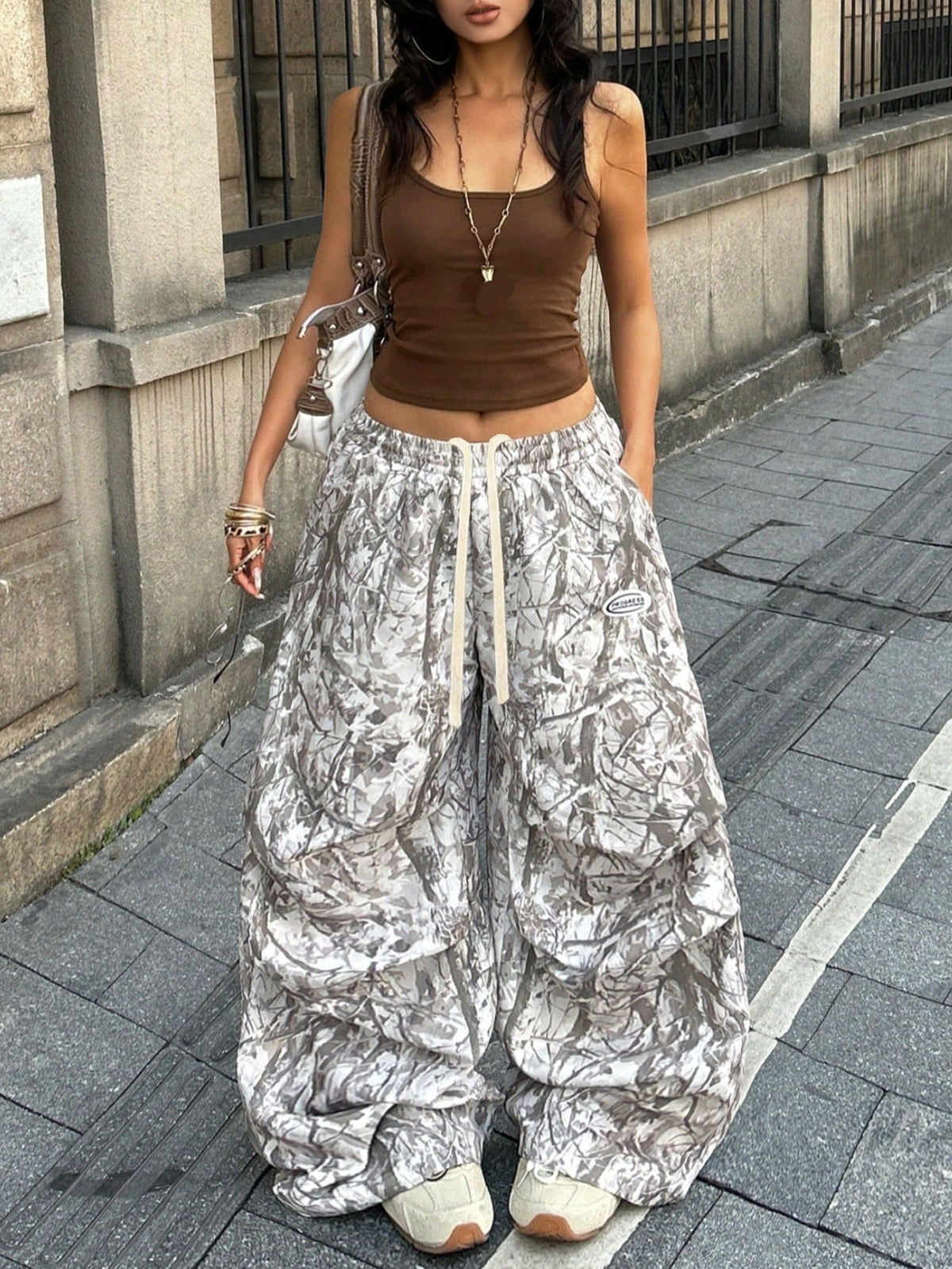 Women's black and white striped wide leg pants featuring an elastic drawstring waistband, side pockets, and a loose straight leg fit.