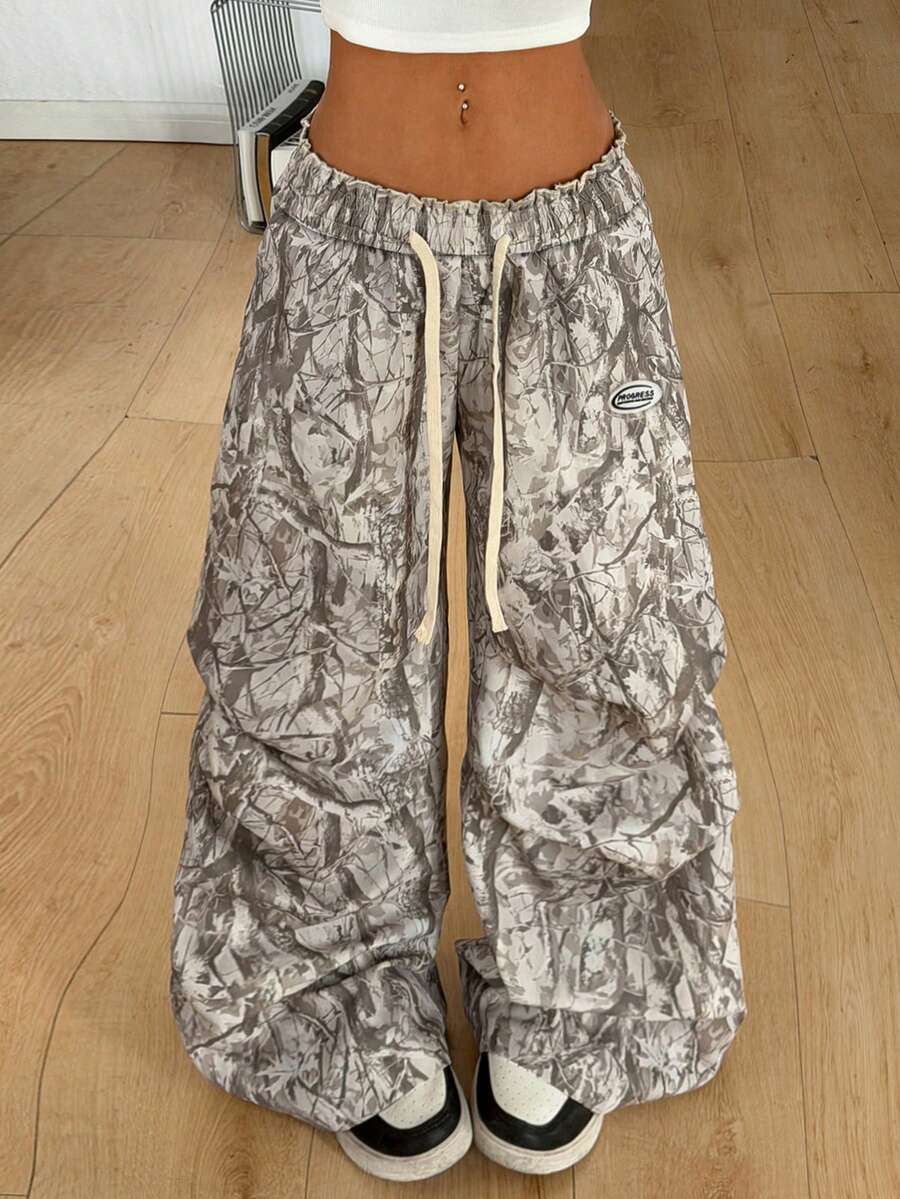 Women's black and white striped wide leg pants featuring an elastic drawstring waistband, side pockets, and a loose straight leg fit.