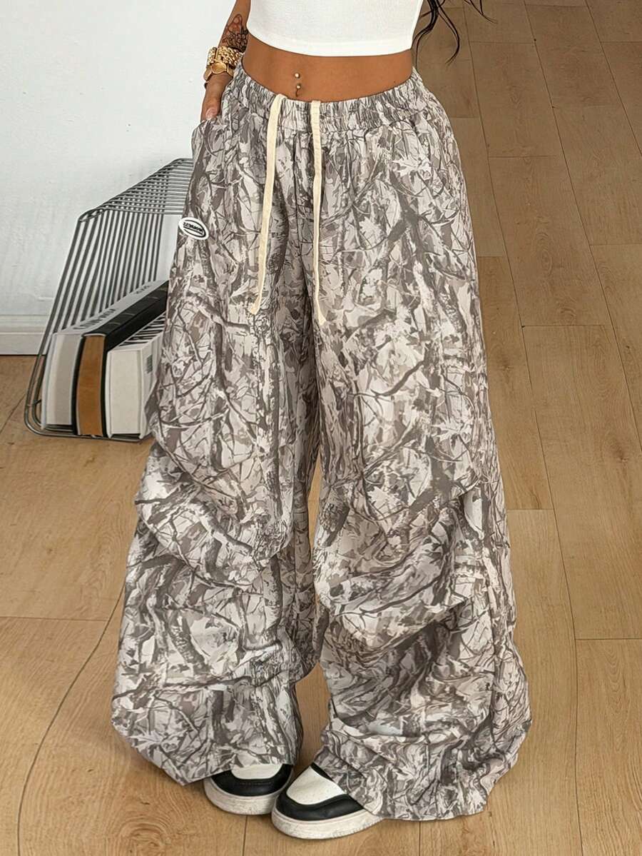 Women's black and white striped wide leg pants featuring an elastic drawstring waistband, side pockets, and a loose straight leg fit.