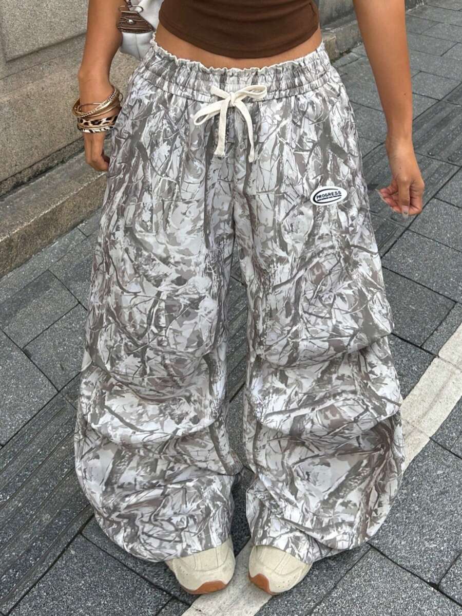 Women's black and white striped wide leg pants featuring an elastic drawstring waistband, side pockets, and a loose straight leg fit.