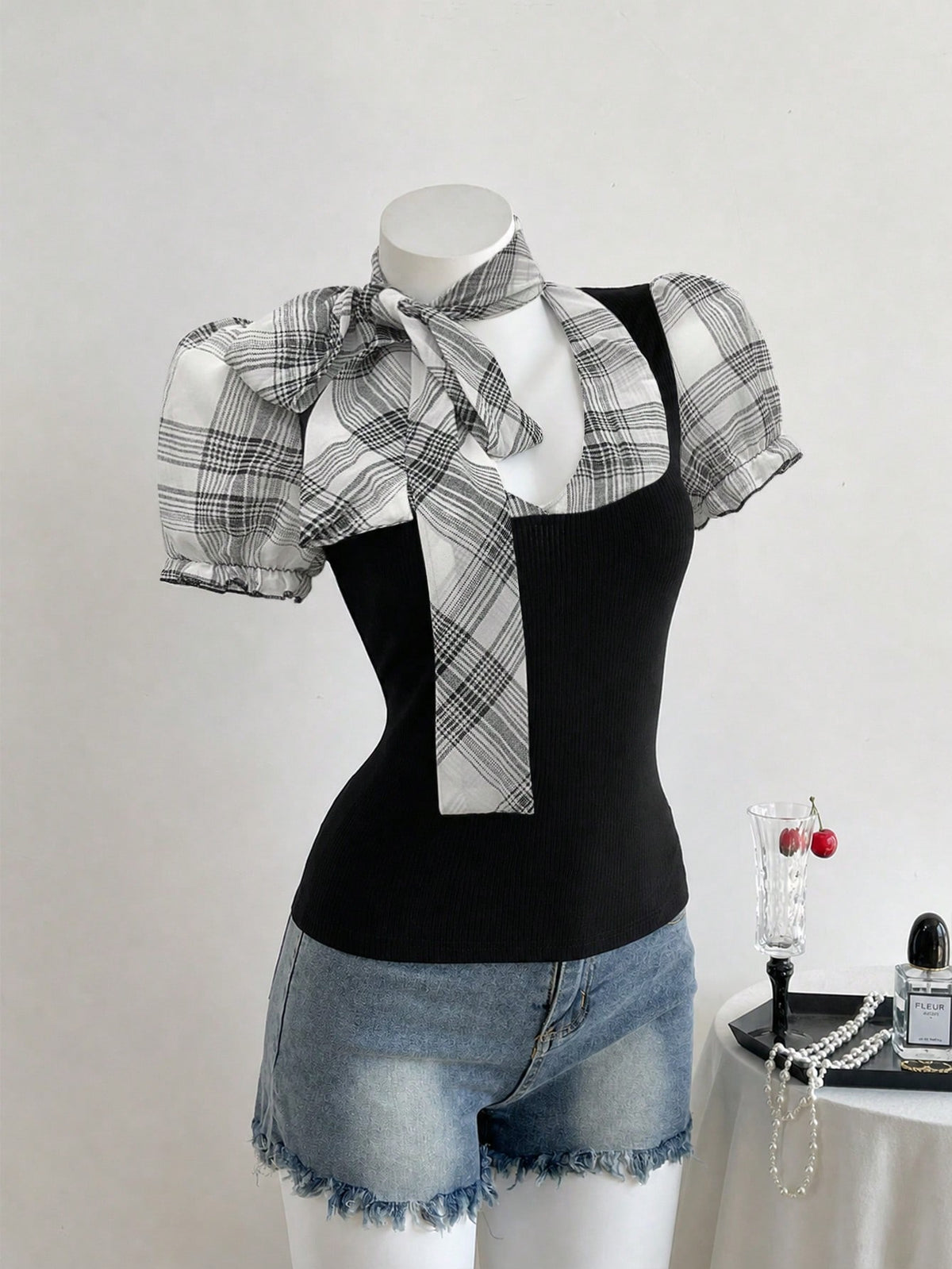 Women's slim fit short sleeve t-shirt featuring puff sleeves, Queen Anne neckline, tie-up front knot, frill detail, and raw hem.
