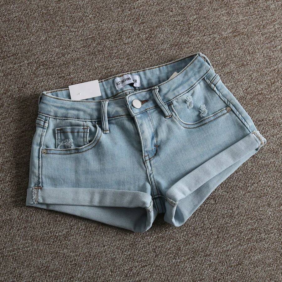 Women's low-waist shorts with ripped hem, asymmetrical detail, straight-leg cut, and pockets.