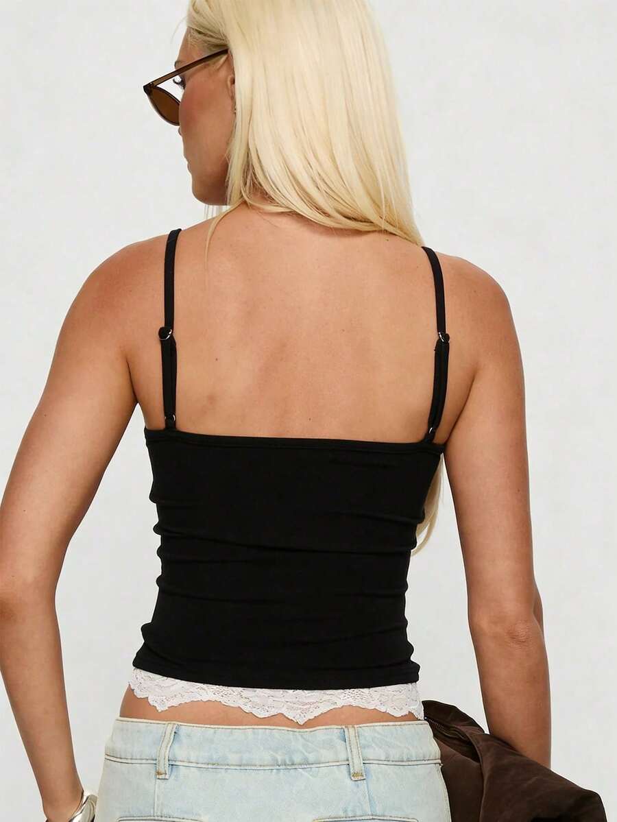 Women's black slim fit camisole top with scoop neckline, spaghetti straps, contrast lace patchwork, and appliqué details