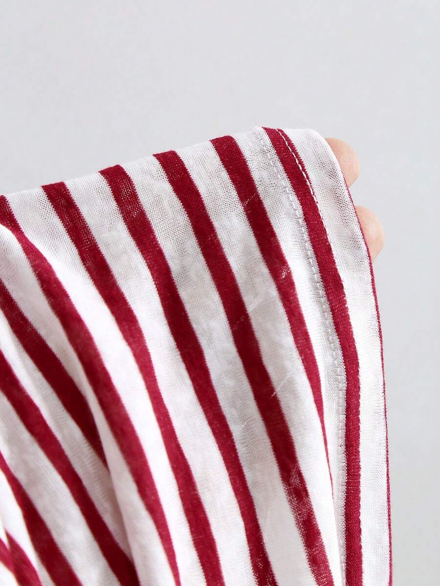 Women's striped tank top featuring an asymmetrical cold shoulder neckline and semi-sheer back.