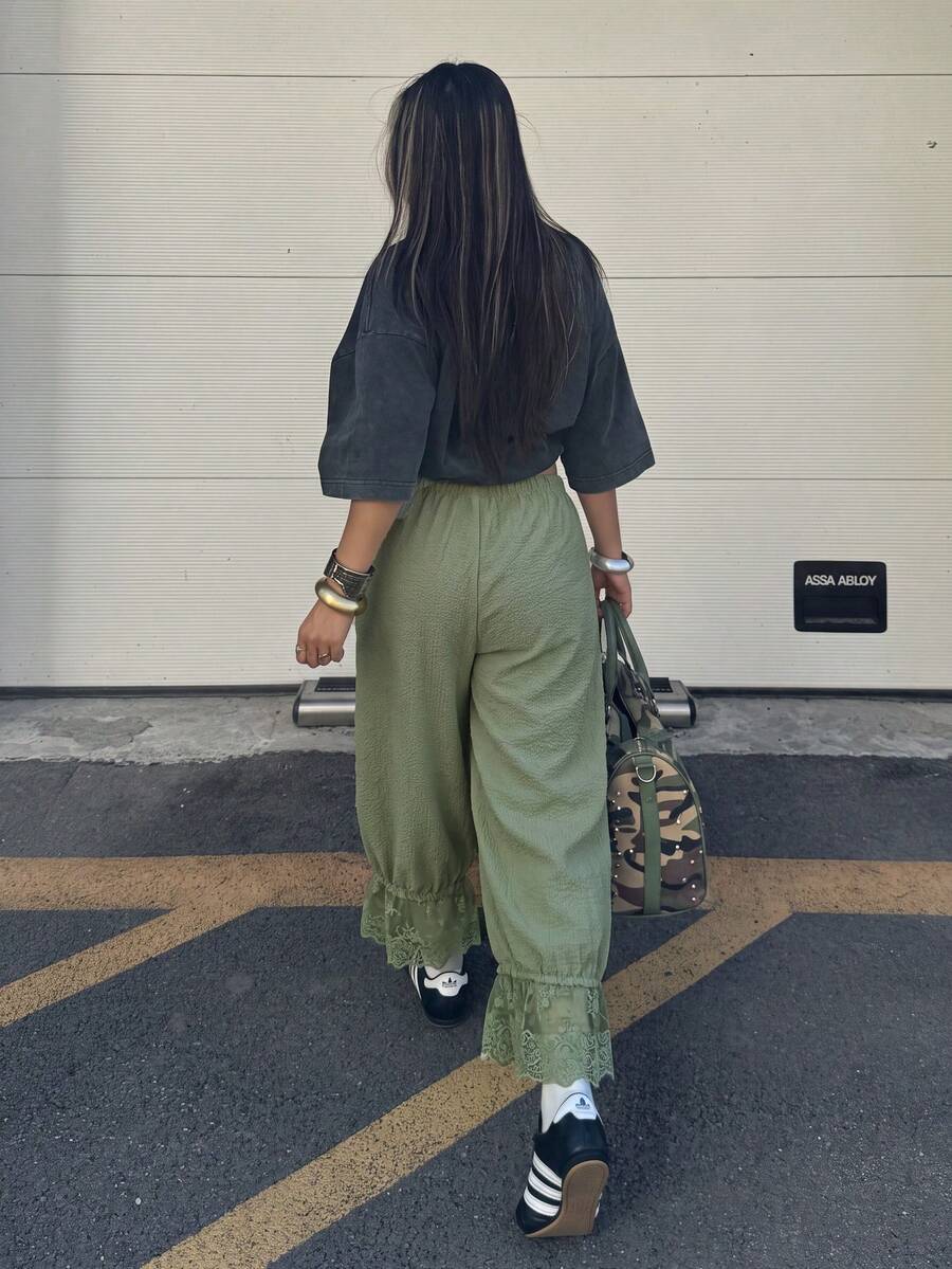 Women's loose-fitting lantern bloomer pants in capri length featuring delicate contrast lace trim and a drawstring waist.