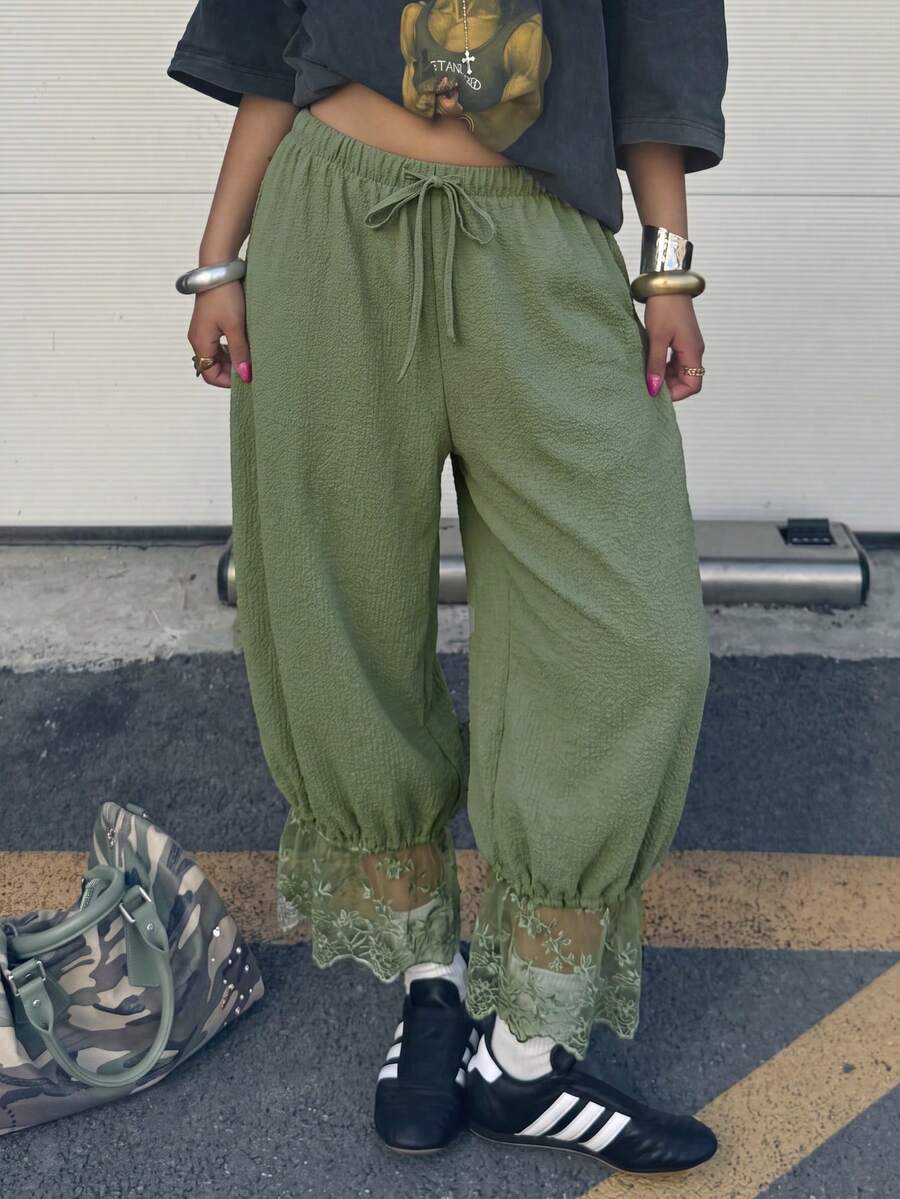 Women's loose-fitting lantern bloomer pants in capri length featuring delicate contrast lace trim and a drawstring waist.