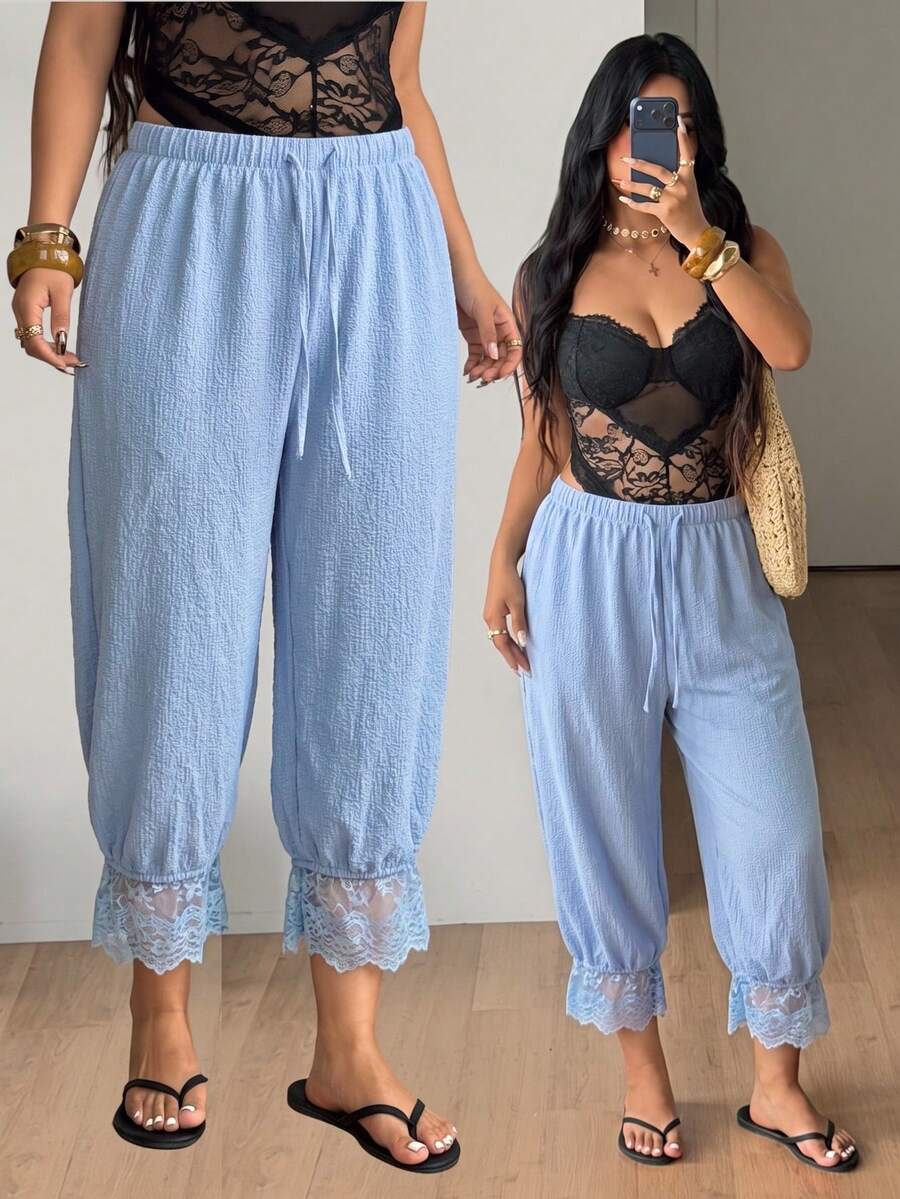 Women's loose-fitting lantern bloomer pants in capri length featuring delicate contrast lace trim and a drawstring waist.