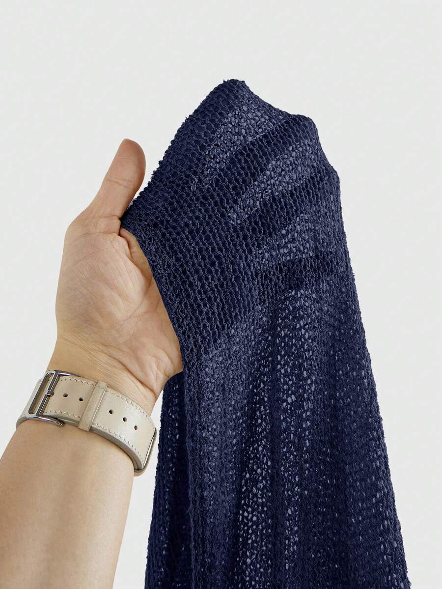 Women's casual hollow knit poncho top with boat neck, cloak sleeves, and asymmetrical hem