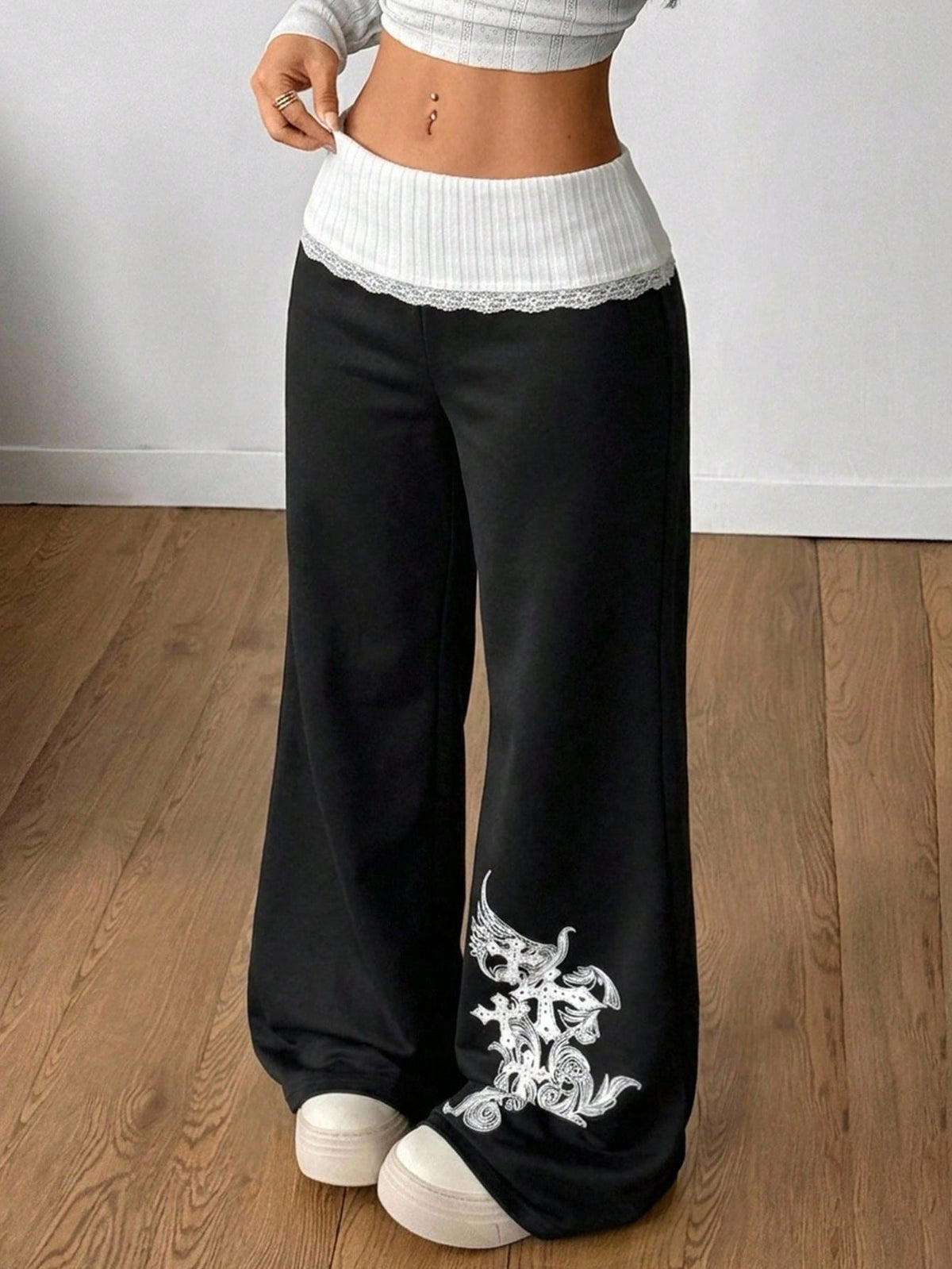 Women's wide leg flare sweatpants featuring a black and white colorblock contrast fold waistband and side stripe details.