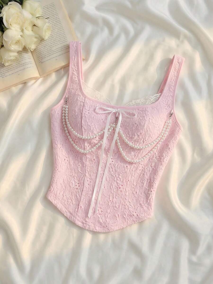 women's black wide-strap tank top featuring a lace collar, detachable bow chain decor with pearl details, and an asymmetrical hem.