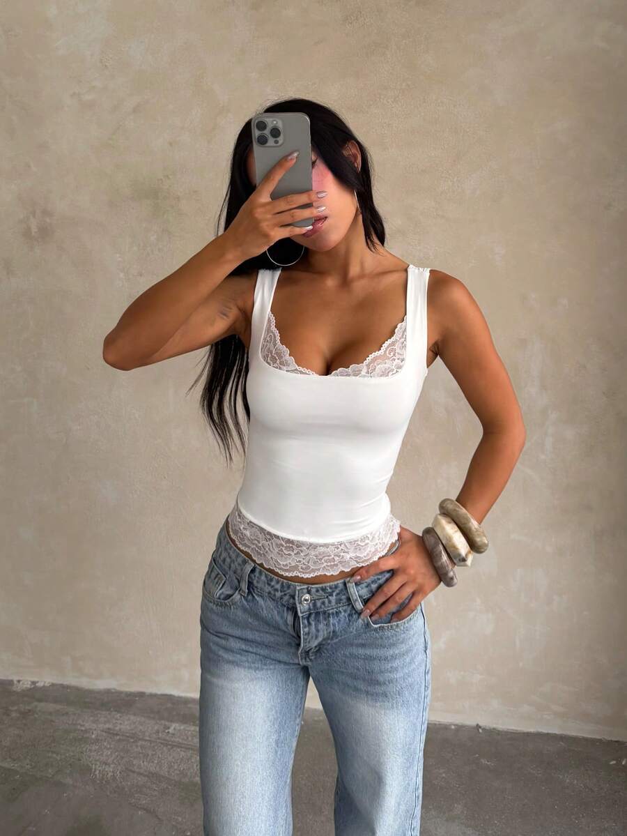 Women's white sleeveless crop tank top with contrast lace details, strap neckline, and graphic plant pattern in a slim fit.