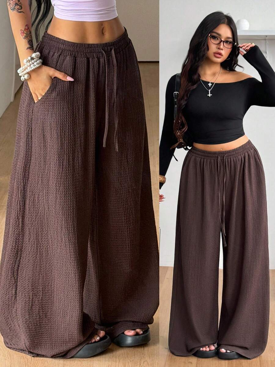 Women's loose straight leg cotton pants featuring a high waist with an adjustable drawstring knot and functional side pockets.