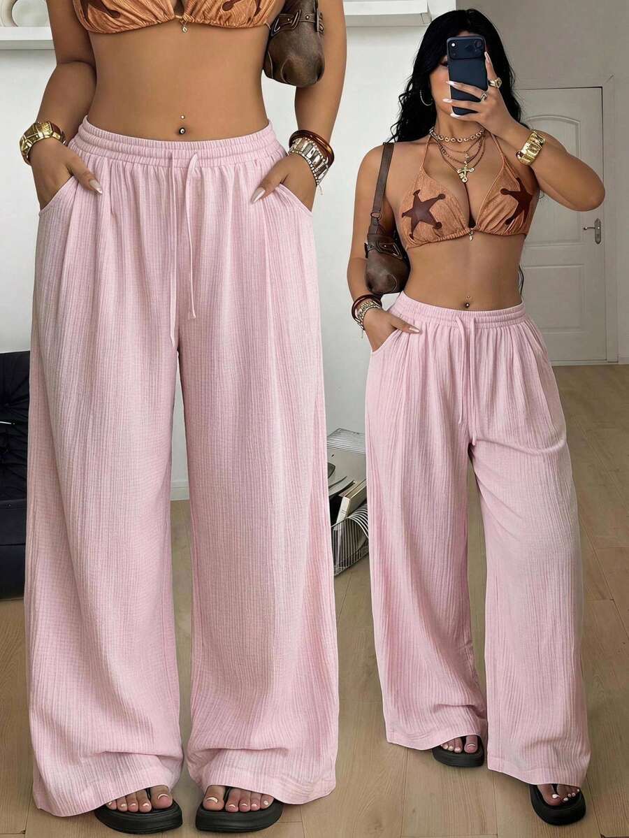 Women's loose straight leg cotton pants featuring a high waist with an adjustable drawstring knot and functional side pockets.