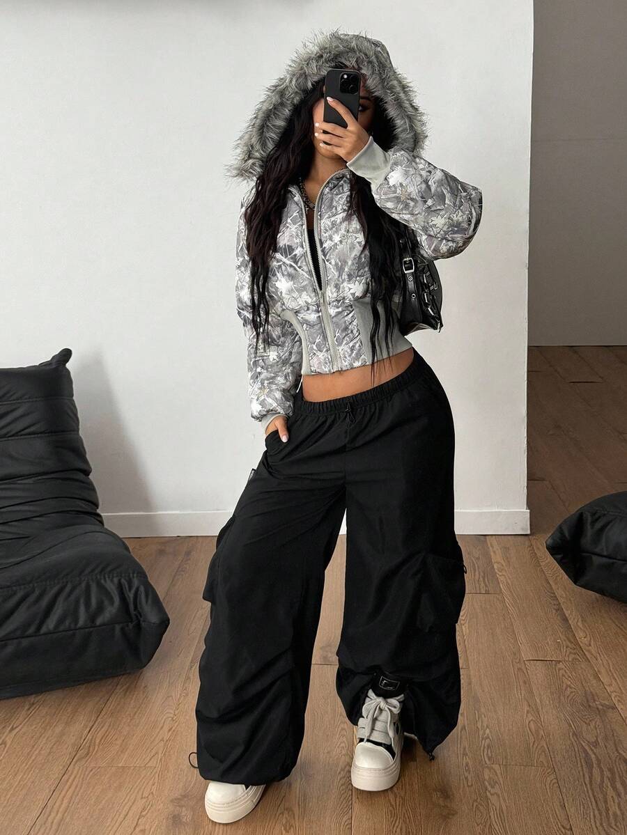 Women's cropped puffer jacket featuring a grey tree branch camo print, zip front, and cozy hooded collar.