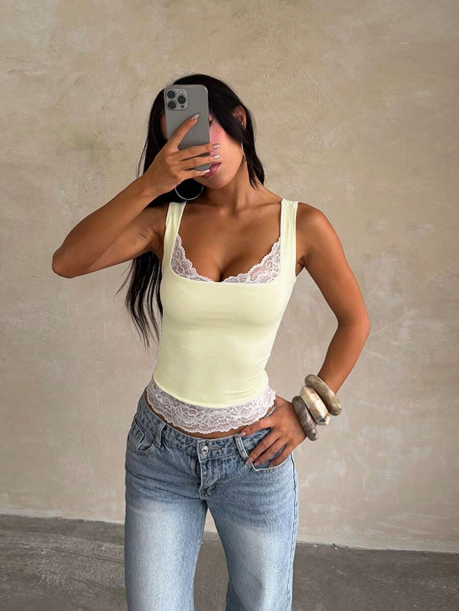 Women's white sleeveless crop tank top with contrast lace details, strap neckline, and graphic plant pattern in a slim fit.