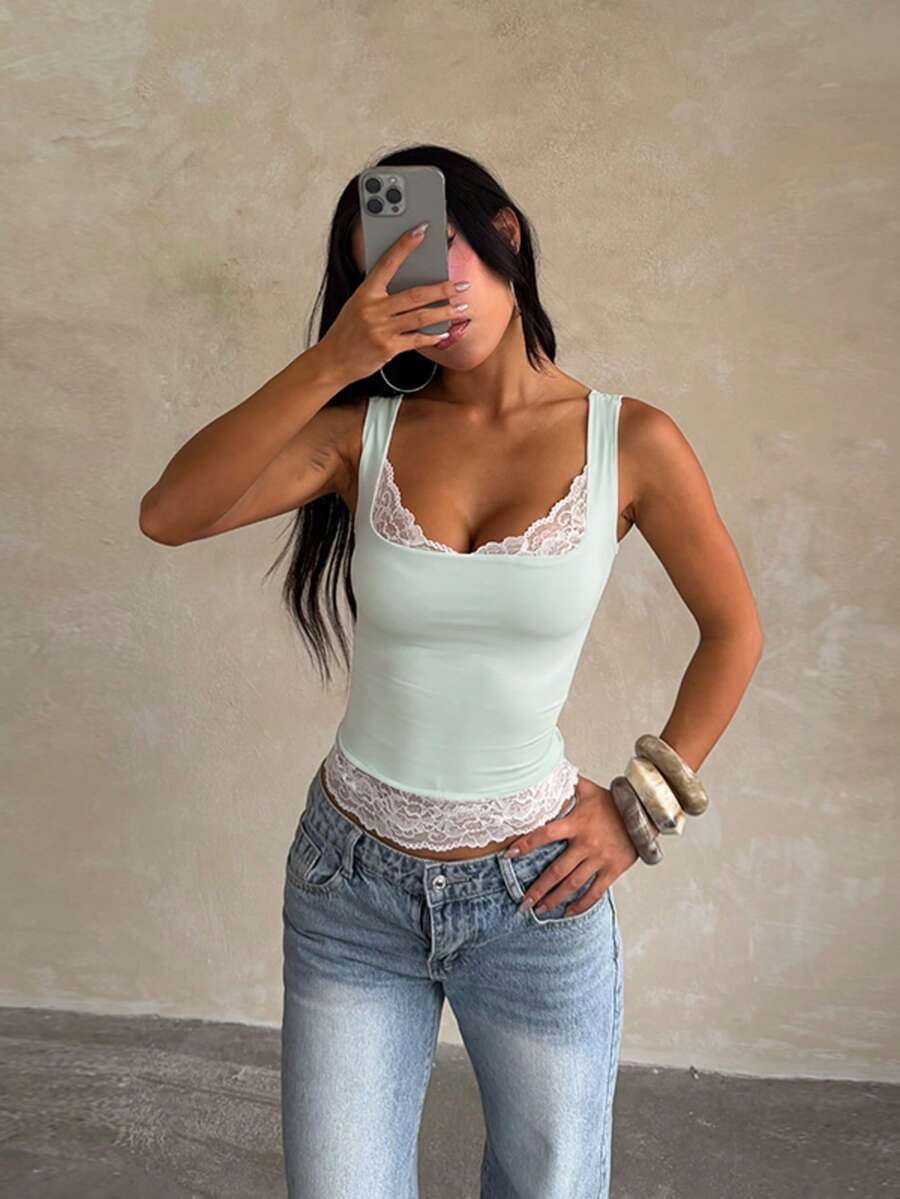 Women's white sleeveless crop tank top with contrast lace details, strap neckline, and graphic plant pattern in a slim fit.