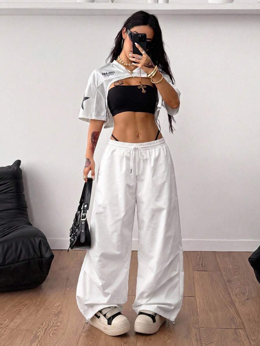 Front view of a women's black and white striped short sleeve crop top with a round neckline and semi-sheer knit finish.