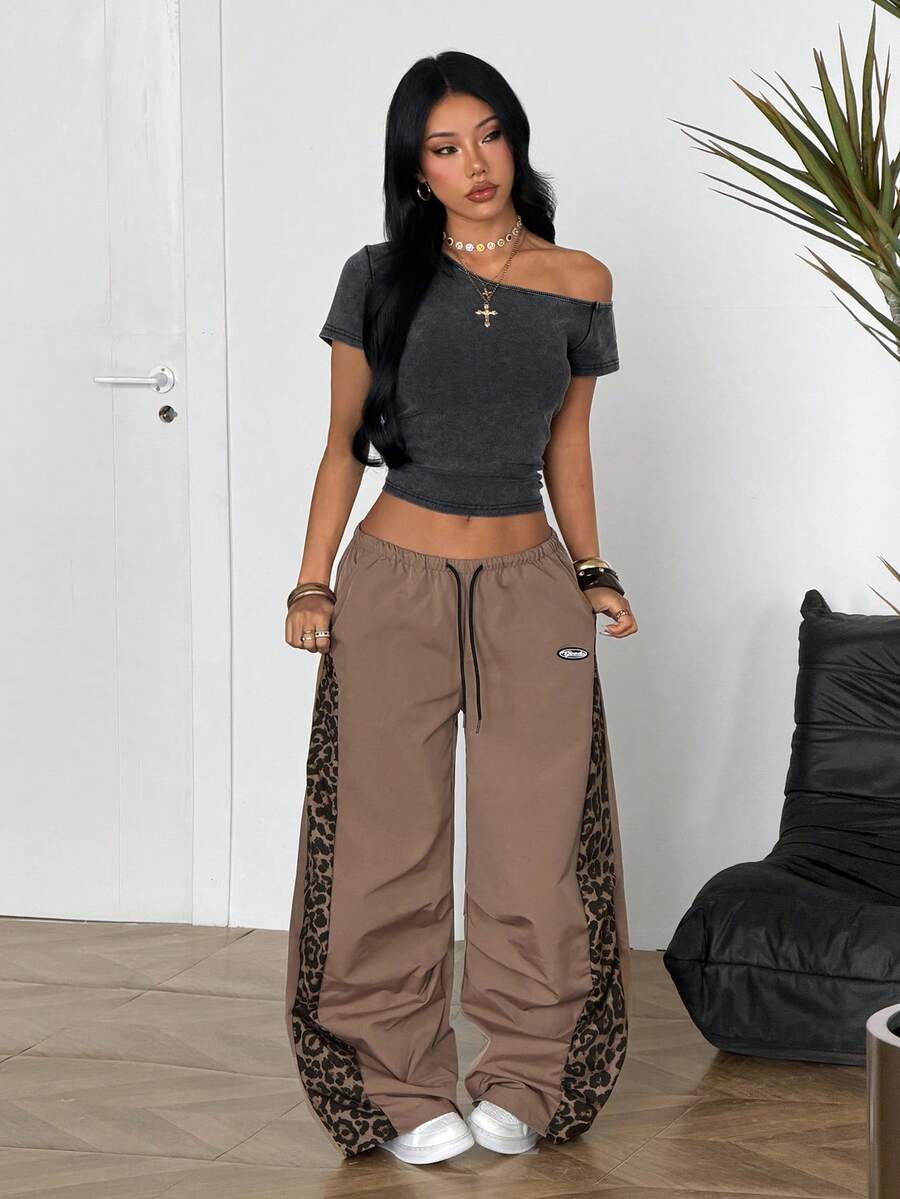 Women's black baggy jogger pants with an adjustable drawstring waist and colorblock polka dot geometric pattern.