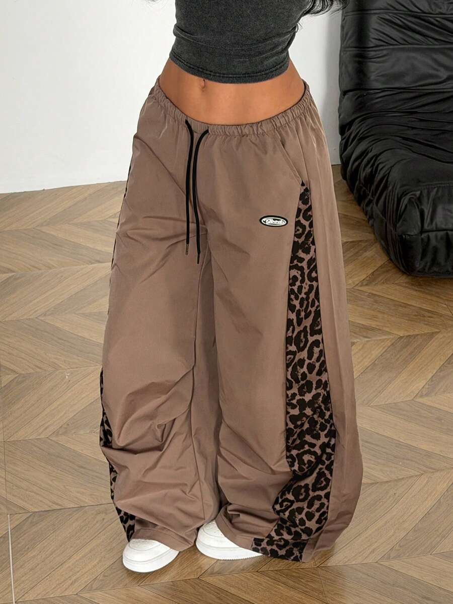 Women's black baggy jogger pants with an adjustable drawstring waist and colorblock polka dot geometric pattern.
