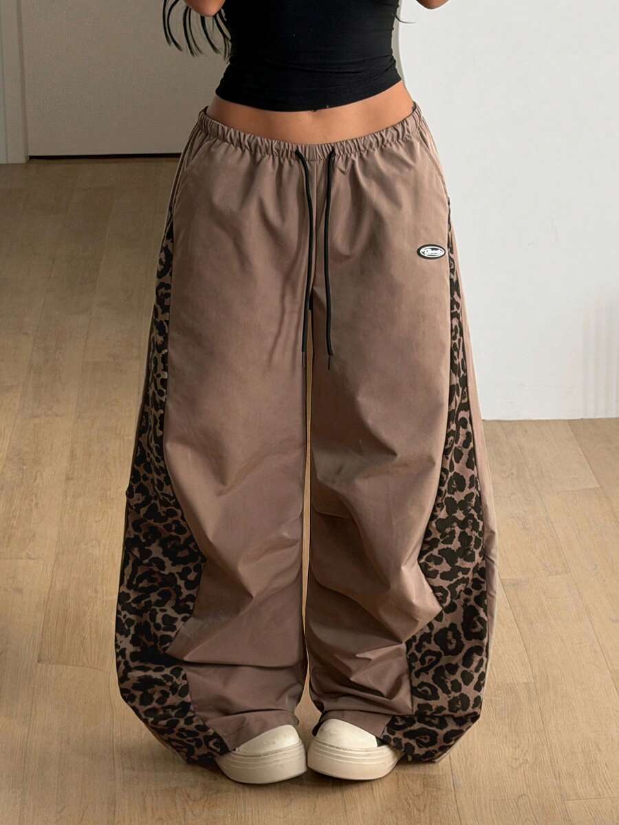 Women's black baggy jogger pants with an adjustable drawstring waist and colorblock polka dot geometric pattern.