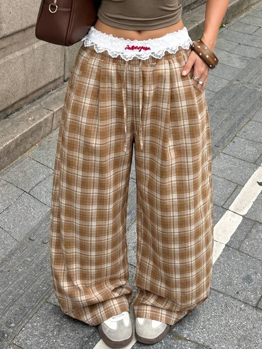 Women's loose fit brown and tan plaid wide leg pants featuring an elastic drawstring waist and side pockets.