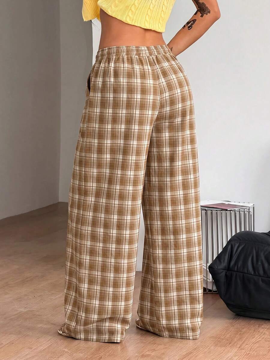 Women's loose fit brown and tan plaid wide leg pants featuring an elastic drawstring waist and side pockets.