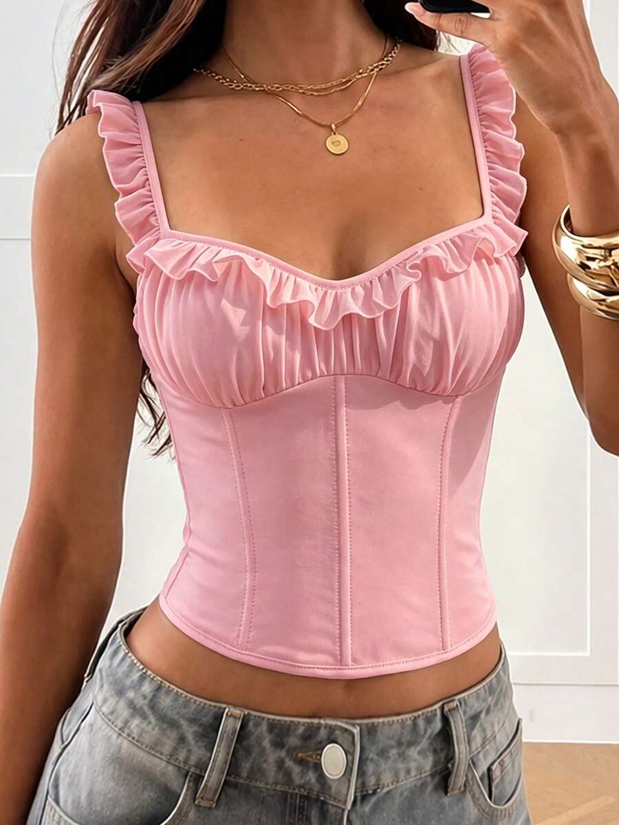 White cropped slim fit camisole top featuring ruffle lettuce trim, lace-up detail, and square neckline.
