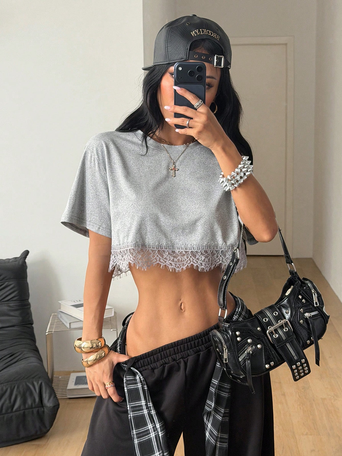 Women's short sleeve crop top with a round neckline and drop shoulder design in black knitted fabric.