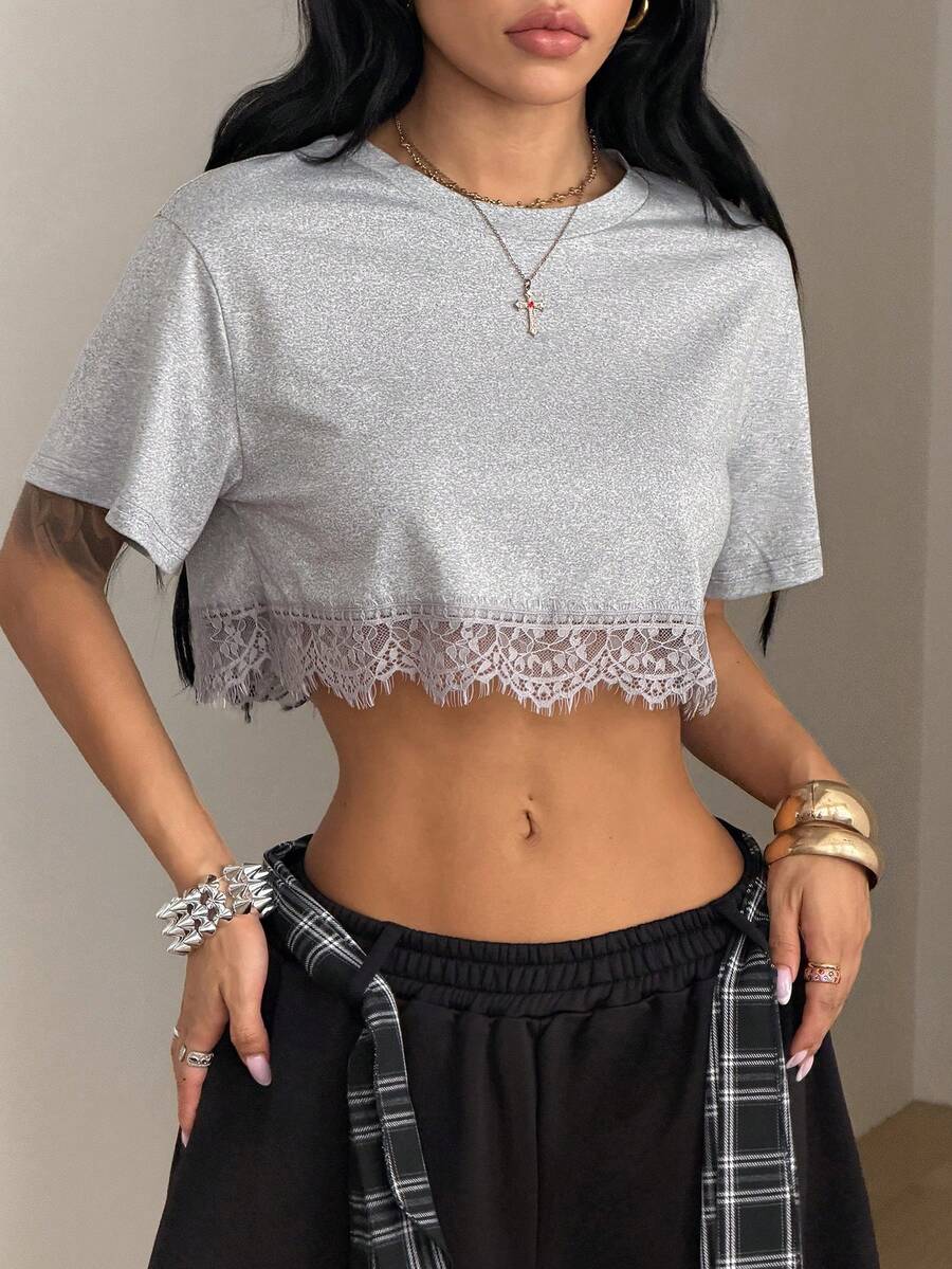 Women's short sleeve crop top with a round neckline and drop shoulder design in black knitted fabric.