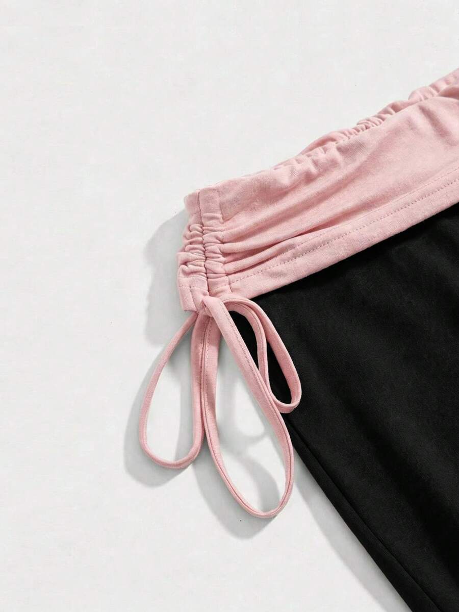 Women's low waist flare leg pants featuring an elastic drawstring waistband and ruched detail in knitted fabric.
