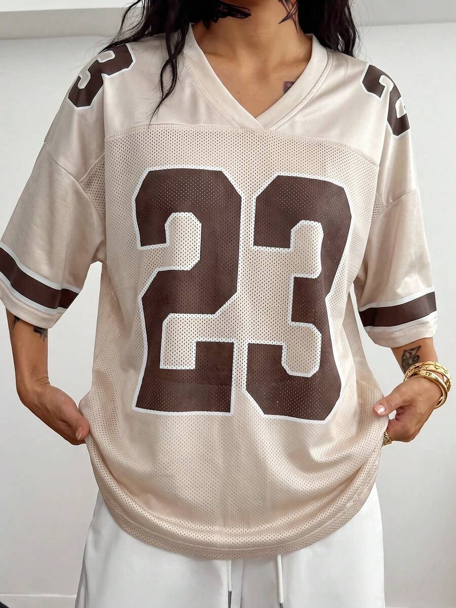 Oversized short-sleeve football jersey top featuring a V-neckline, contrast binding, and graphic number print.